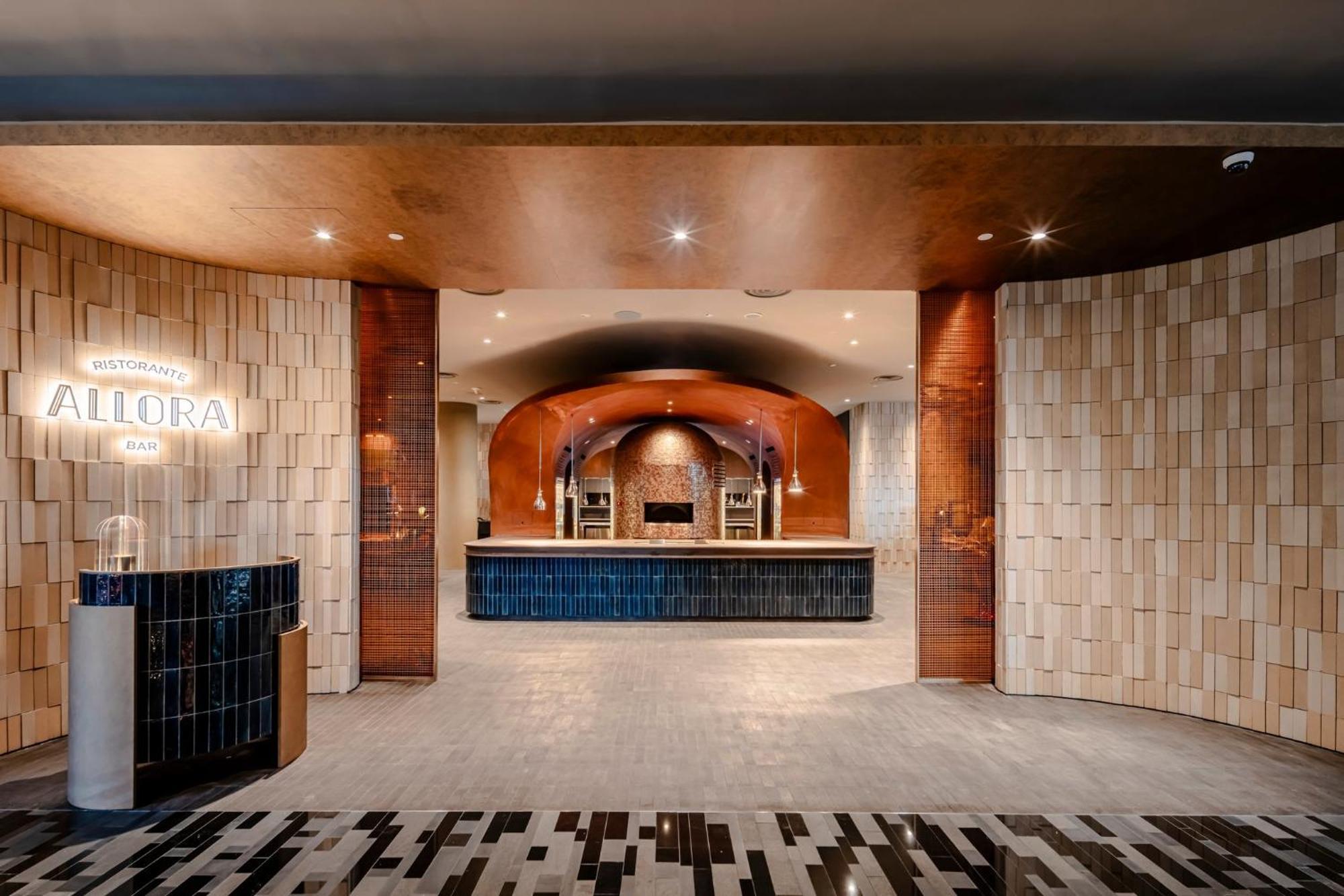 Crowne Plaza Changi Airport By Ihg Singapore Exterior foto The photo shows a modern reception area, characterized by a stylish and elegant design. The space features a combination of textured wall panels, including light-colored tiles and warm-toned materials. In the center, there is a sleek reception desk a