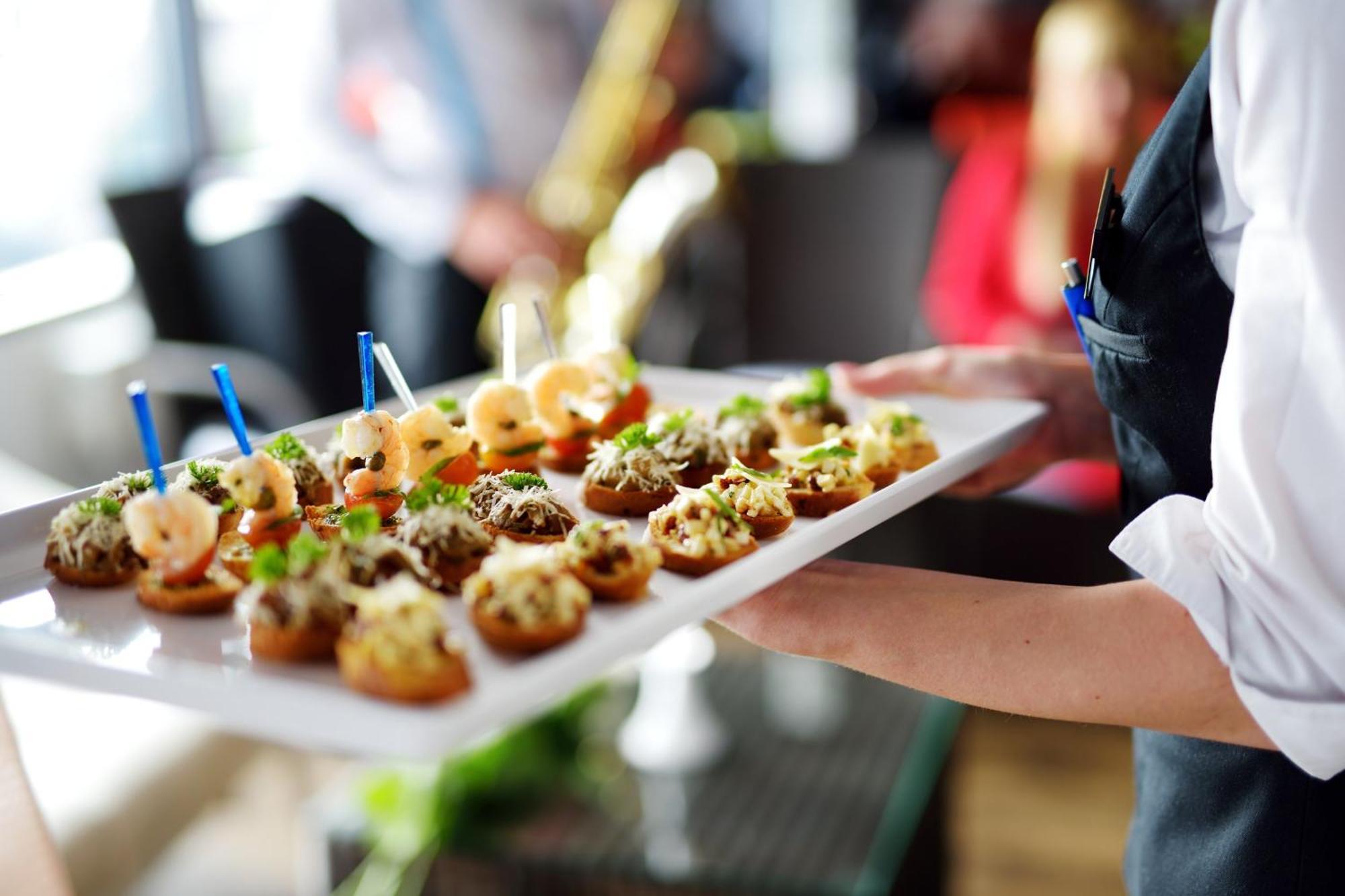 Crowne Plaza Changi Airport By Ihg Singapore Exterior foto The photo shows a tray of appetizers being held by a waiter. The tray is filled with various small bites that appear to be decorative and gourmet. Some of the appetizers feature toppings such as shrimp and what looks like a mix of herbs or spreads. T